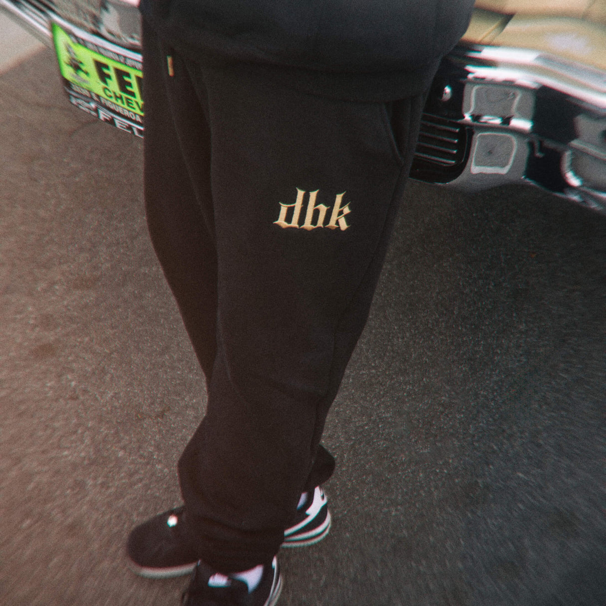 Black sweatpants with small gold dbk logo on the upper thigh.
