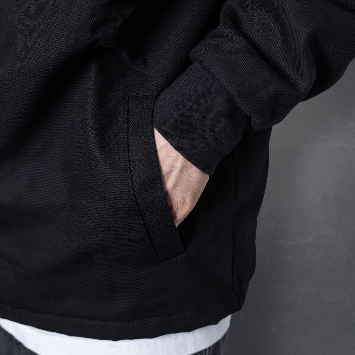 Black jacket sleeve and hem with side pocket opening and curved stitching