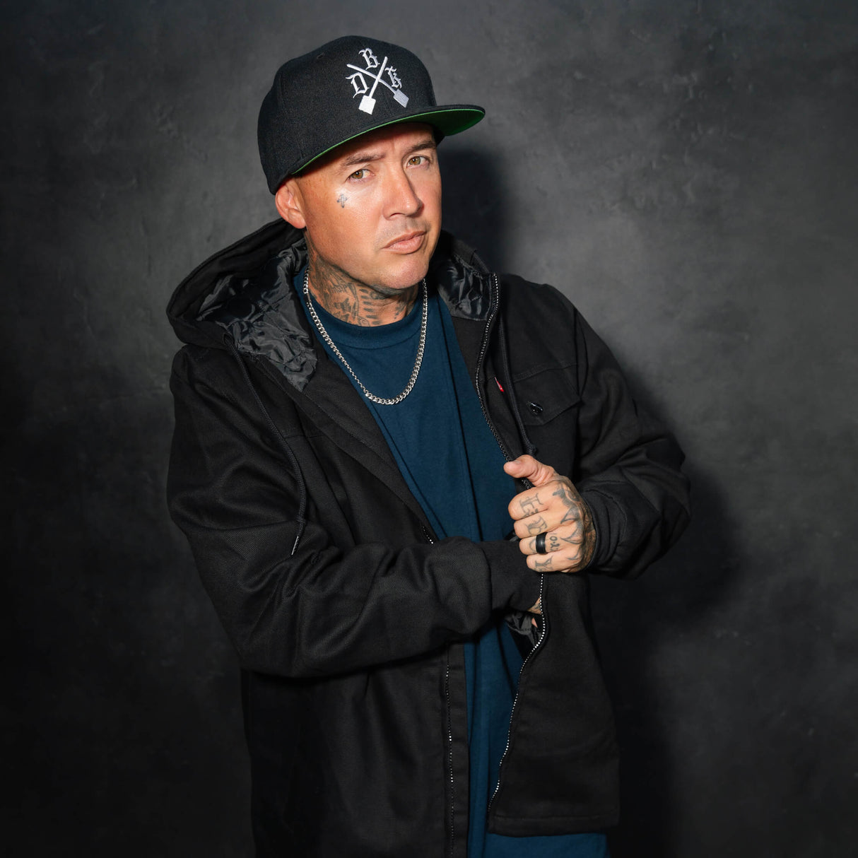 Black zip-front jacket with chest pockets and visible interior hood lining
