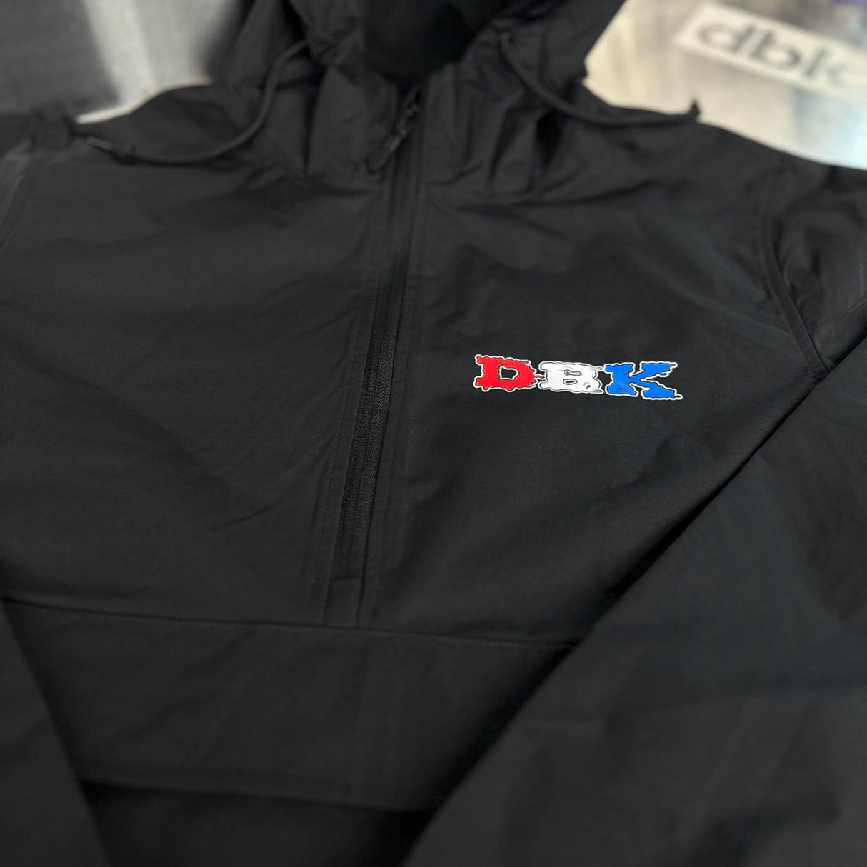 Black windbreaker front zipper and small DBK logo on chest