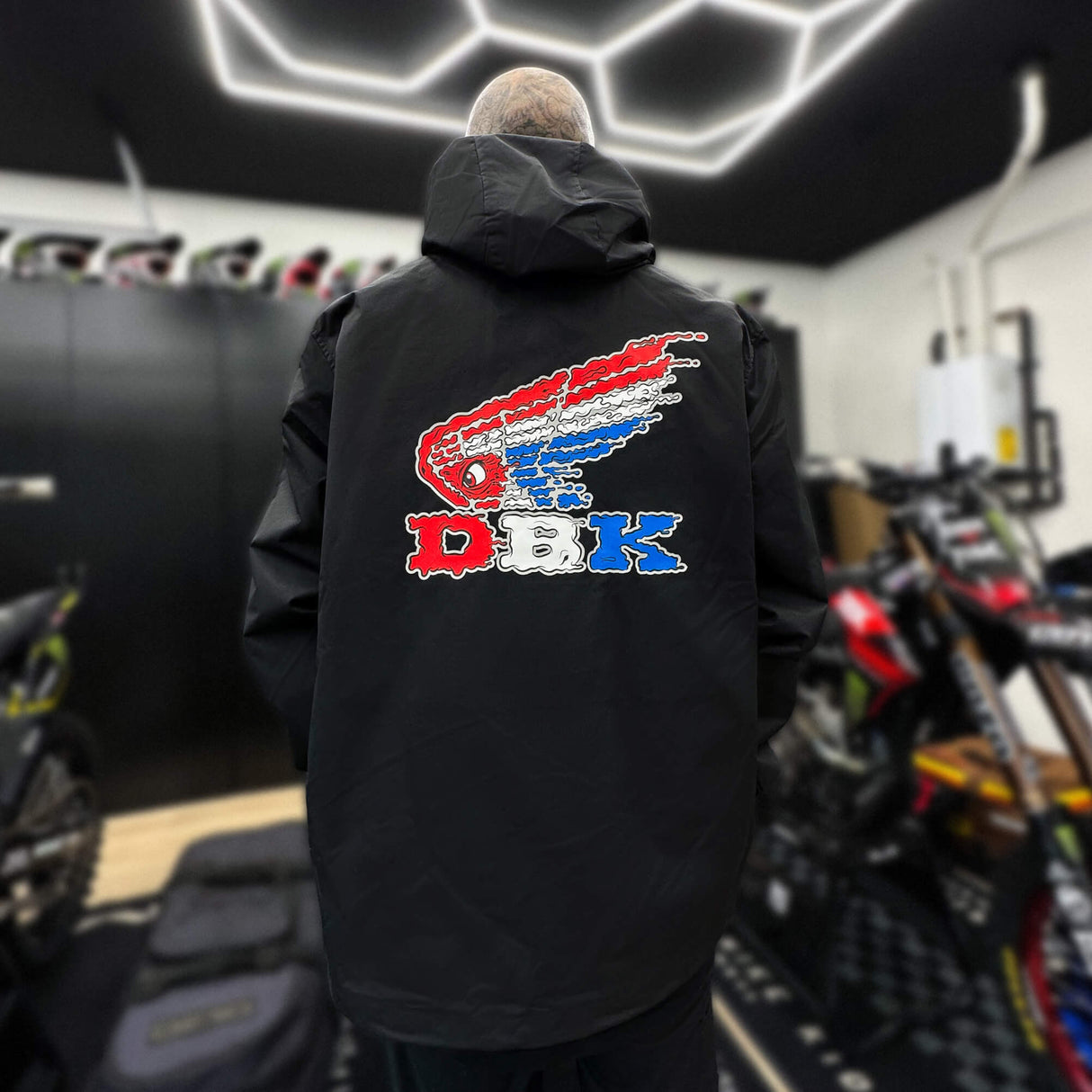 Black windbreaker with hood and large DBK logo graphic on back