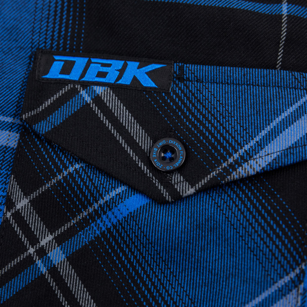 Blue-and-black plaid flannel shirt close-up of chest pocket and button detail