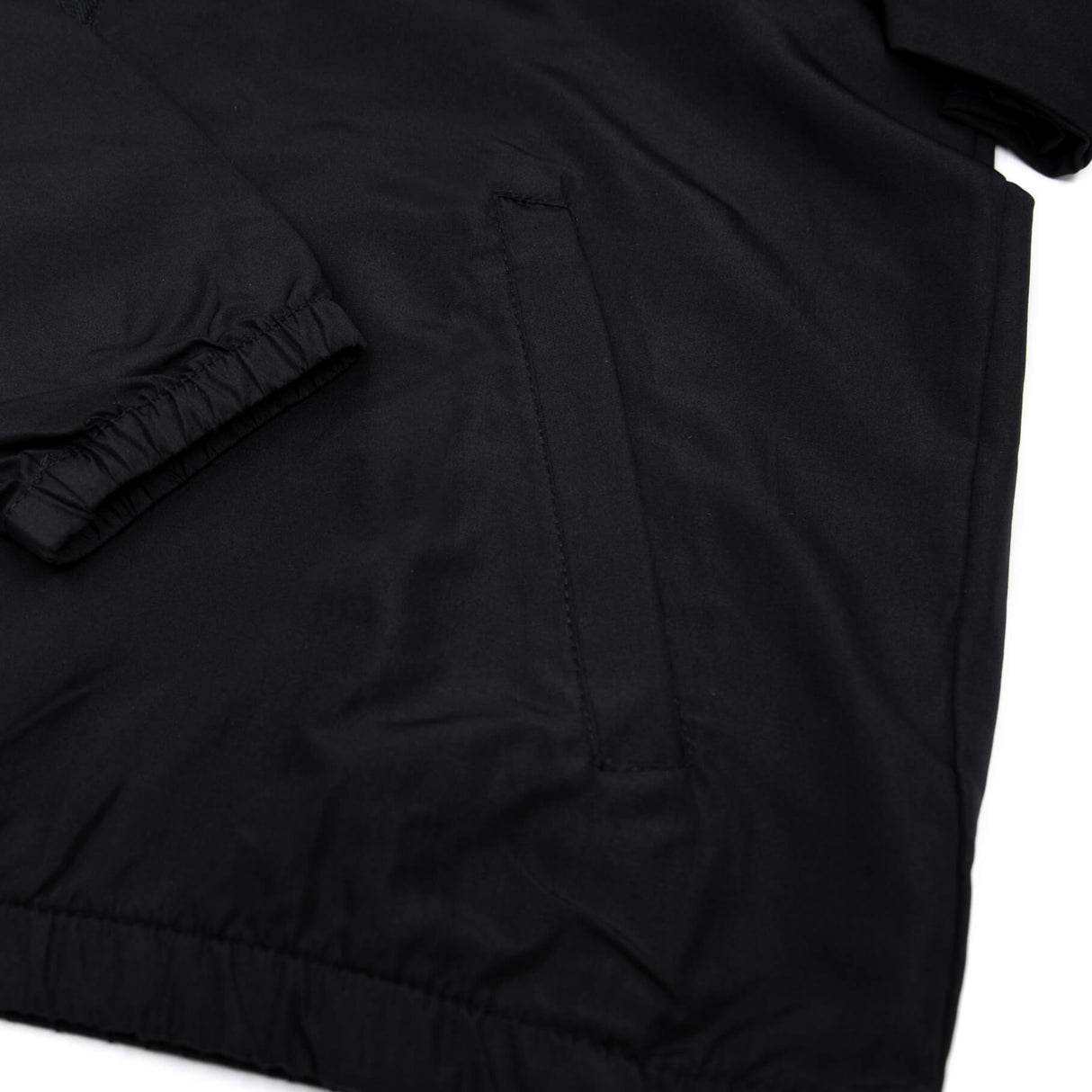 Black youth windbreaker close-up of fabric and sleeve seam with stitched paneling