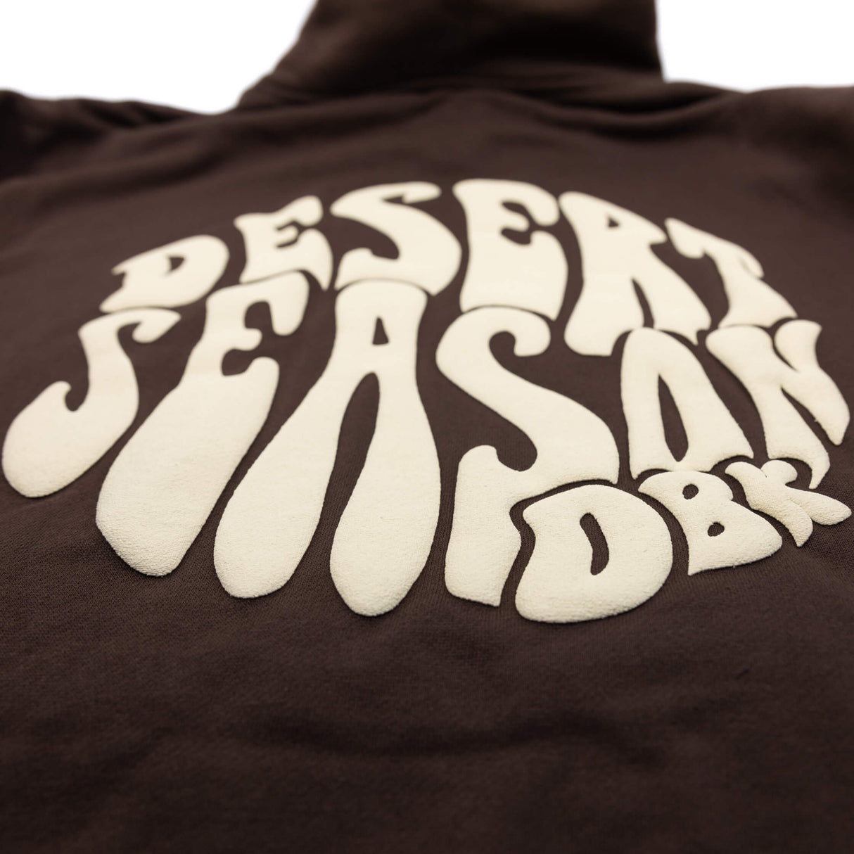 Desert Season Hoodie Nahaufnahme: großer weißer Logo-Schriftzug