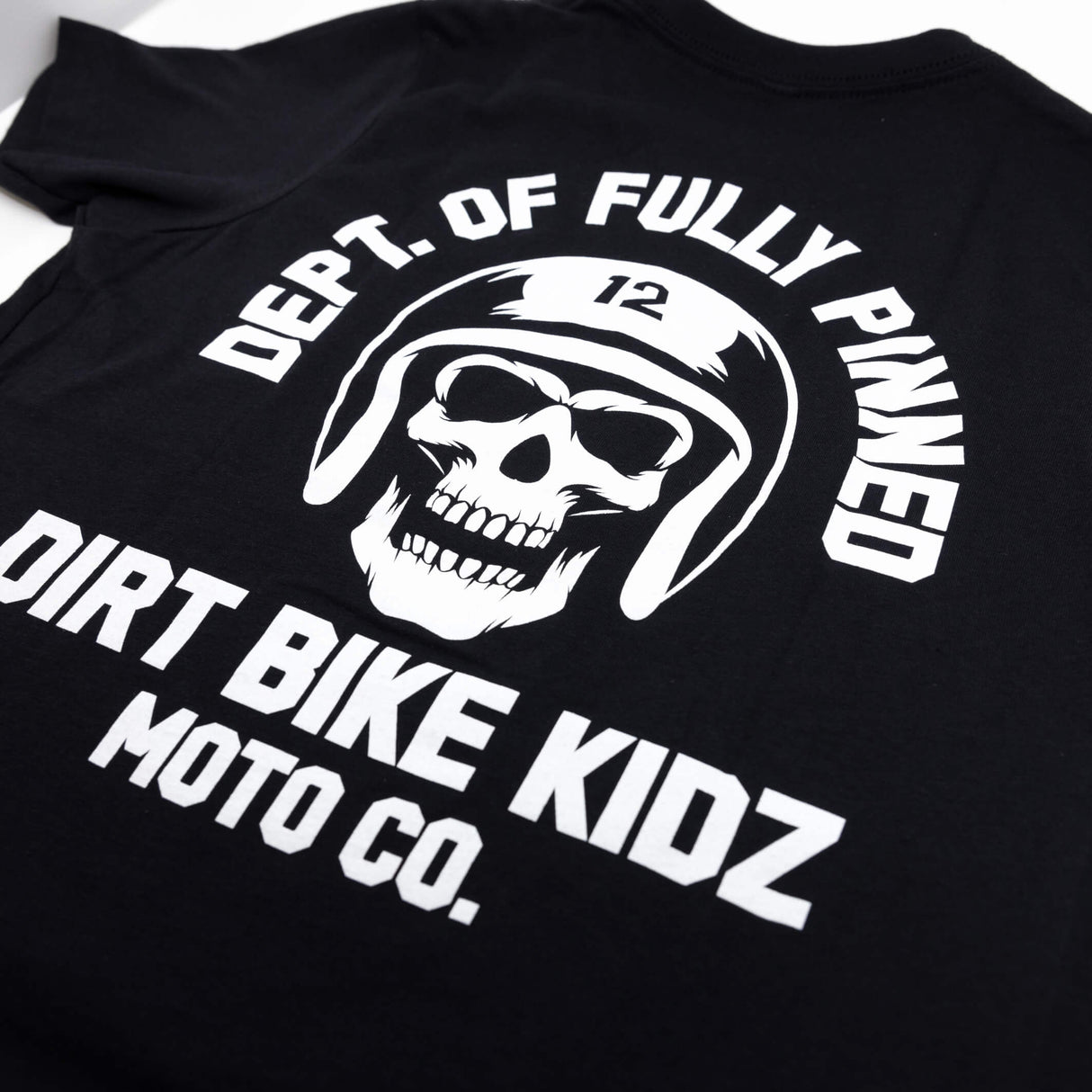 Youth premium black T-shirt back close-up showing skull helmet graphic and “DIRT BIKE KIDZ”