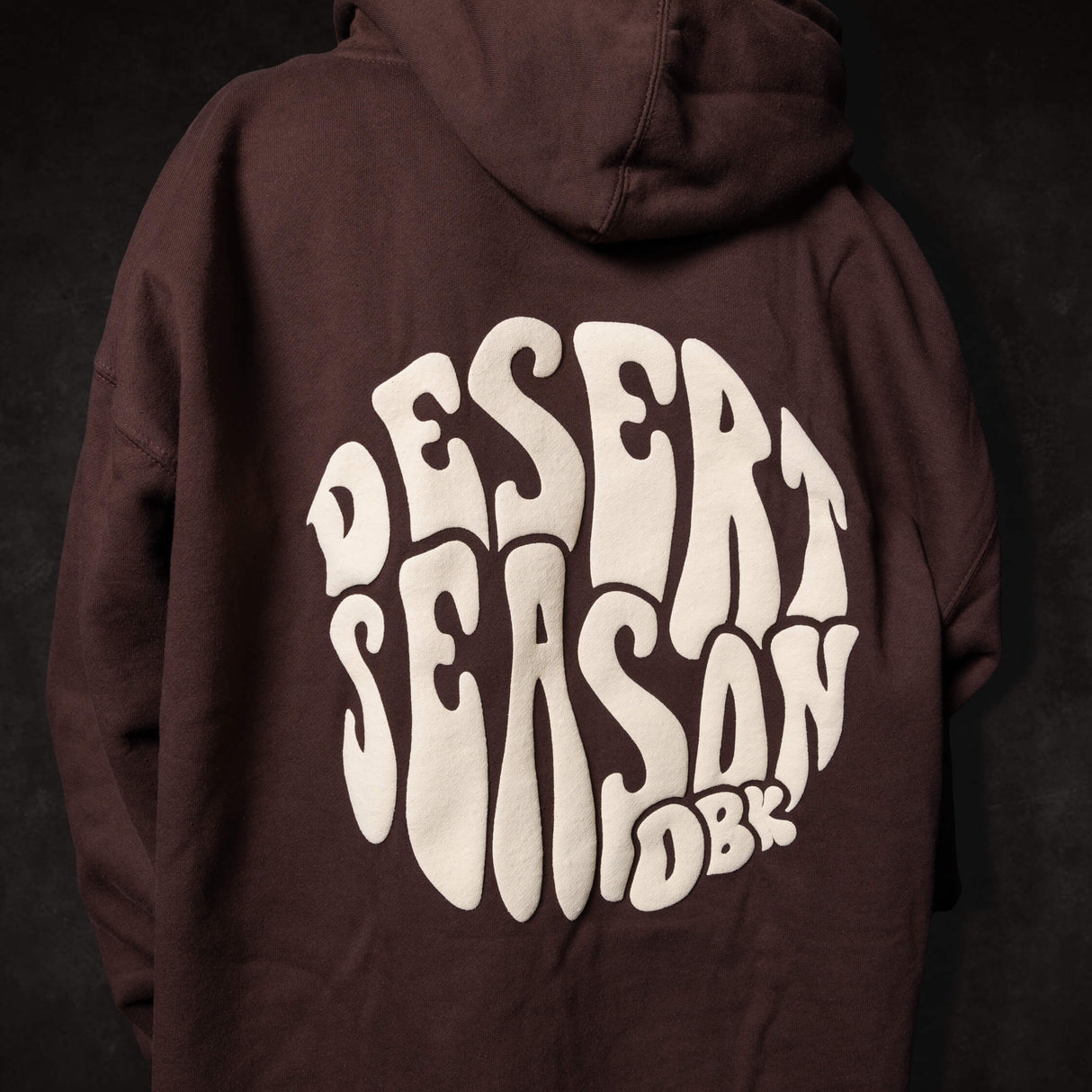 Dark brown Desert Season hoodie with large back graphic print and attached hood