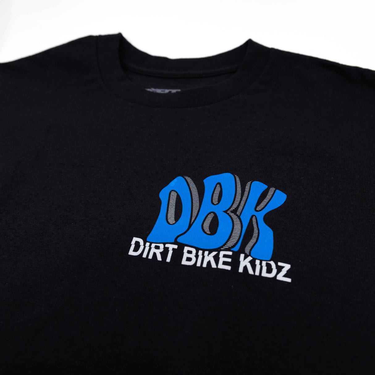 Black tee close-up showing blue DBK Dirt Bike Kidz chest graphic.