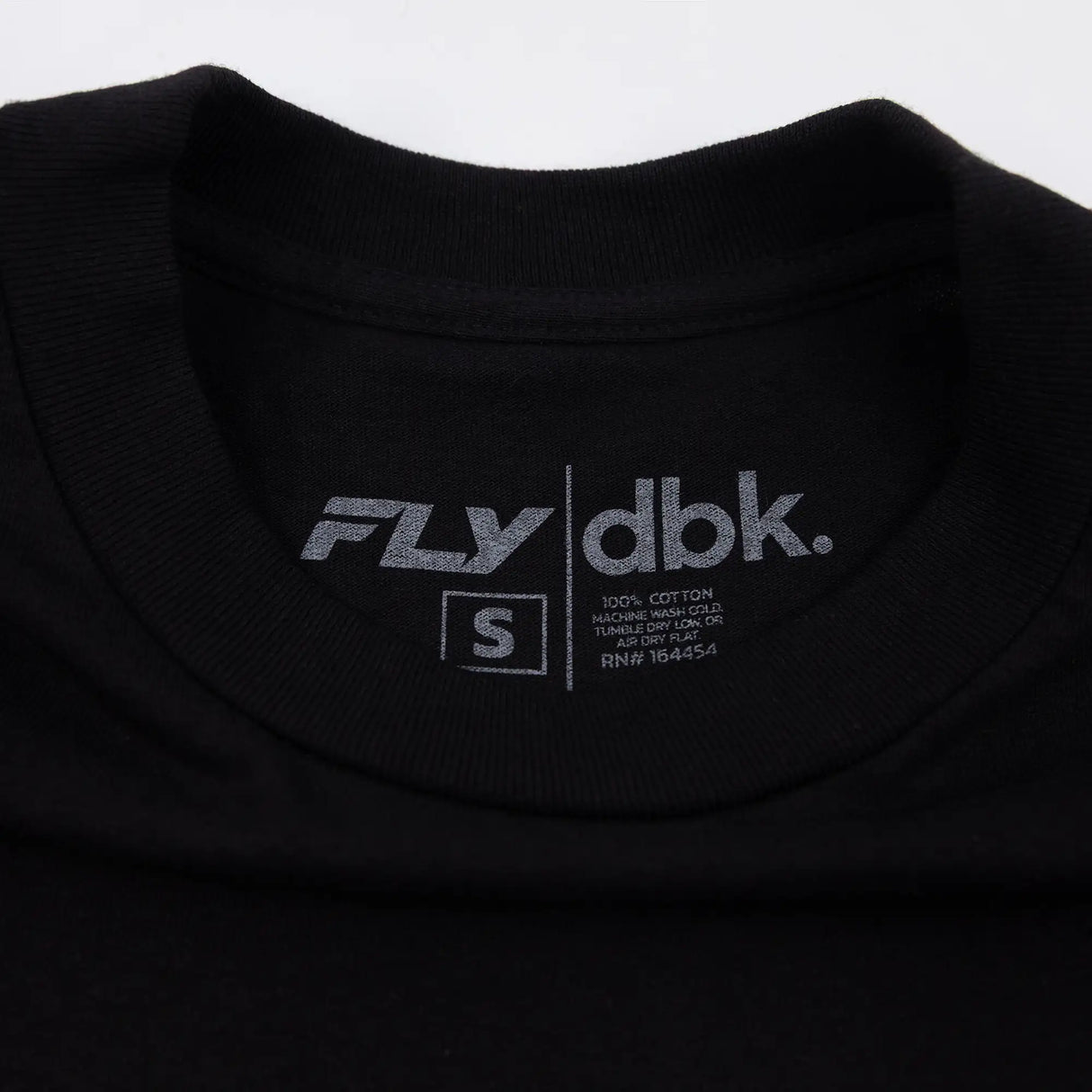 Black T-shirt back neck label with dbk logo and small size text.