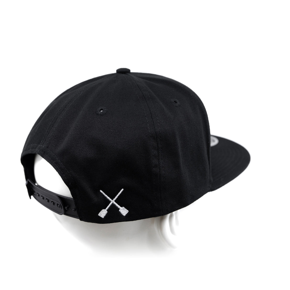 Black snapback cap with X logo near side panel and adjustable back strap