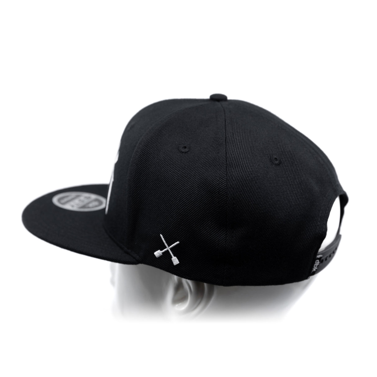 Black baseball cap with white crossbones logo and side panel view