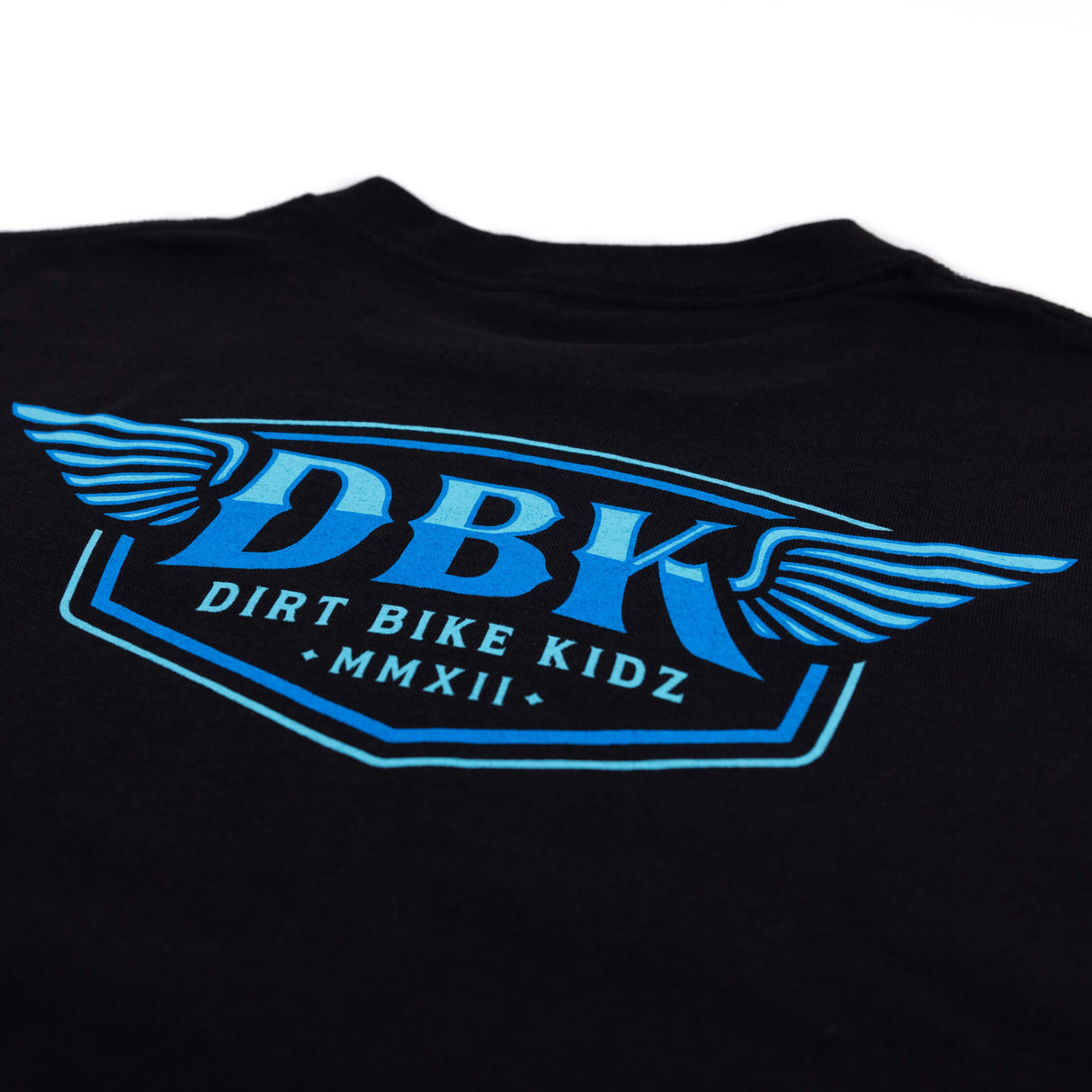 Close-up of black T-shirt with large blue DBK graphic and winged logo.