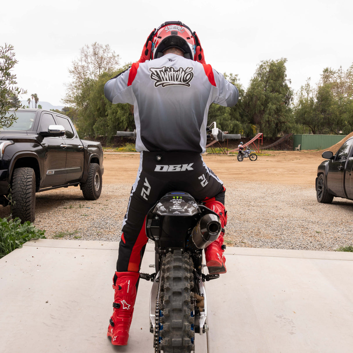 Motocross jersey back view in light gray and black gradient with red shoulders and gray sleeve details