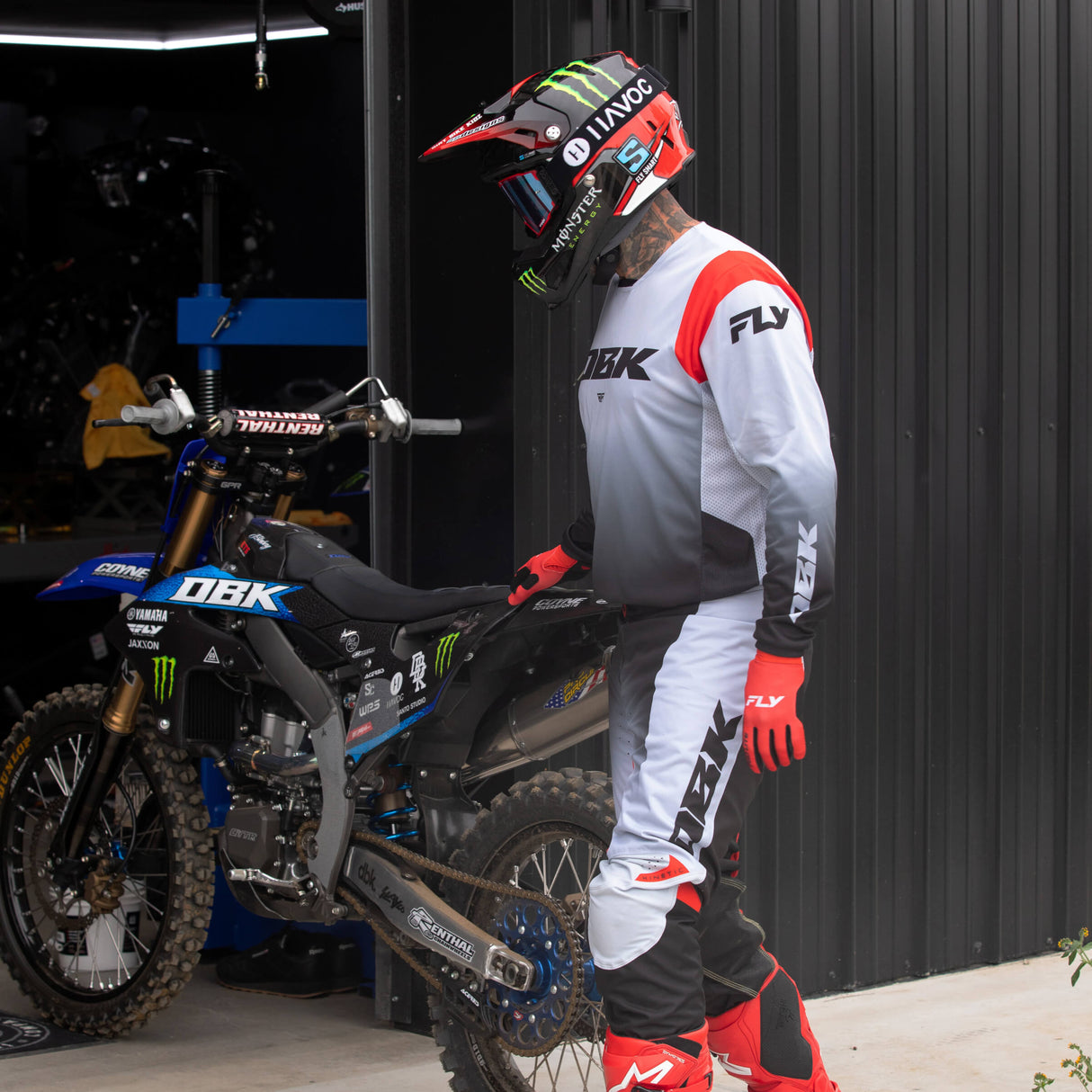 Motocross jersey in light gray and black with red shoulder panel, mesh side panels, and sleeve graphics