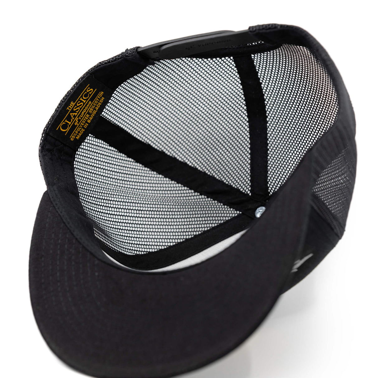 Black mesh trucker hat interior with contrast fabric panels and adjustable strap
