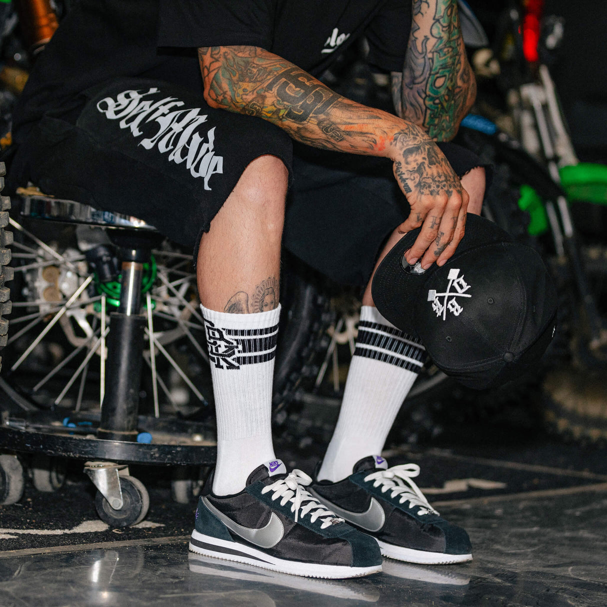 Crew socks worn with sneakers: white cuff sock with logo stripe and black toe/heel.