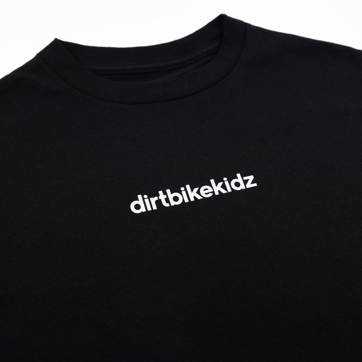 Black crewneck tee close-up: white 'dirtbikekidz' chest print