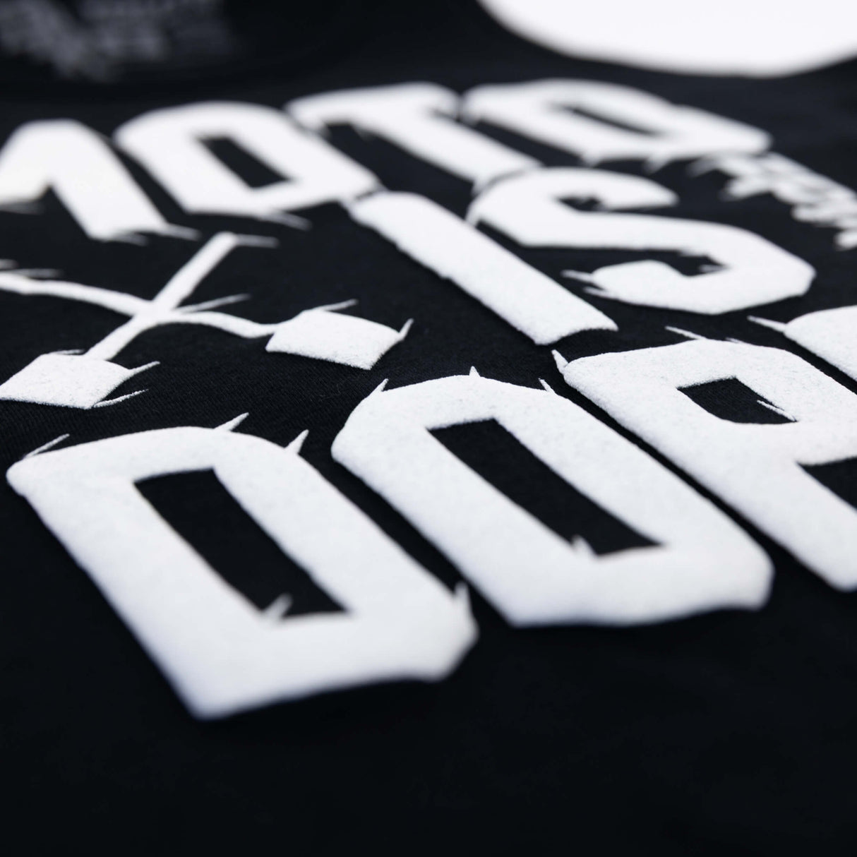 Close-up of white Moto Is Dope lettering on black youth tank top