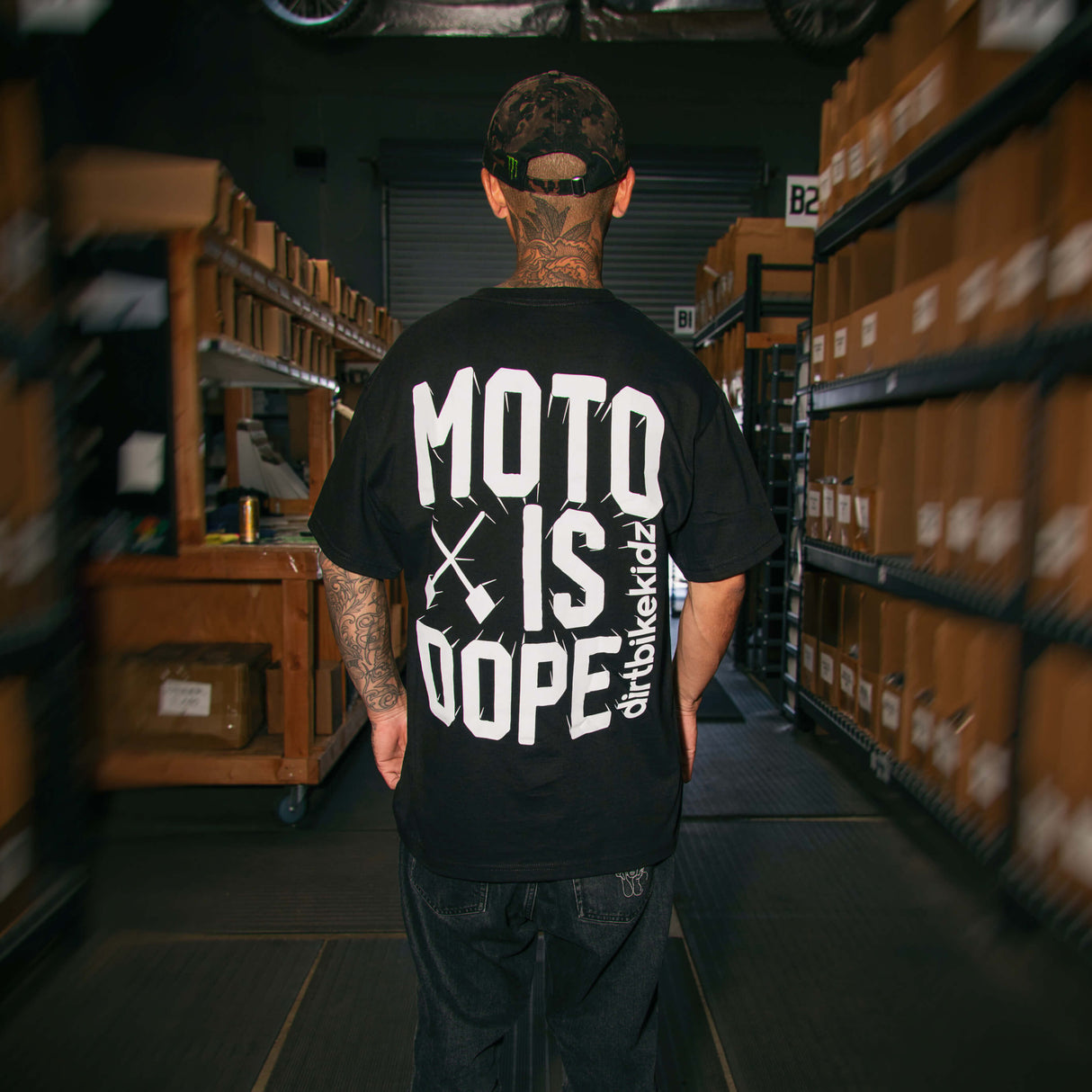 Black crewneck tee with large white 'MOTO IS DOPE' back graphic