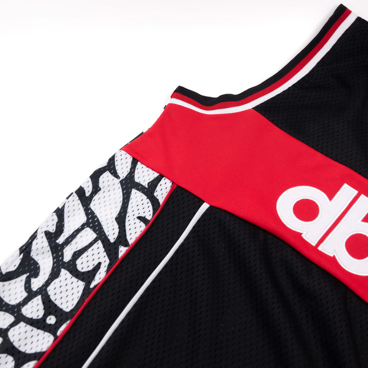 Black jersey tank with red upper panel and white-red striped neckline trim.