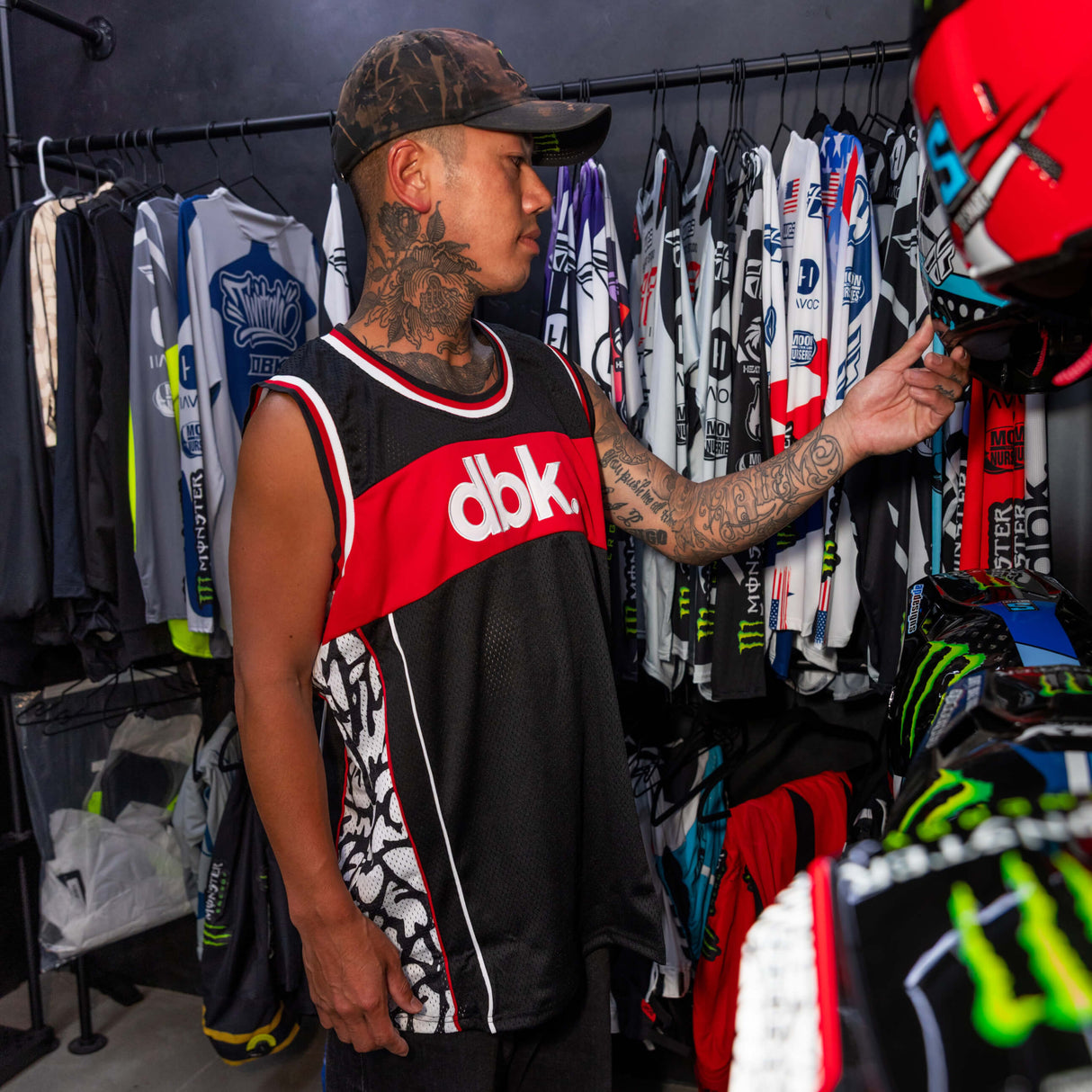 Sleeveless black jersey tank with red dbk logo band and white-red collar trim.