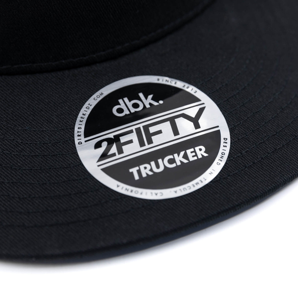 Black trucker cap circular 2FIFTY TRUCKER logo patch on brim