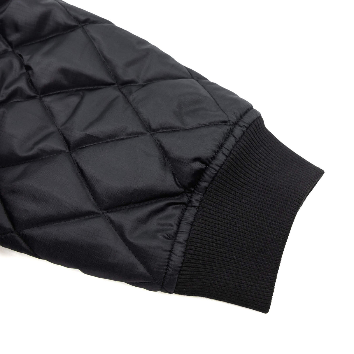 Black quilted jacket sleeve with ribbed cuff and diamond stitch detailing