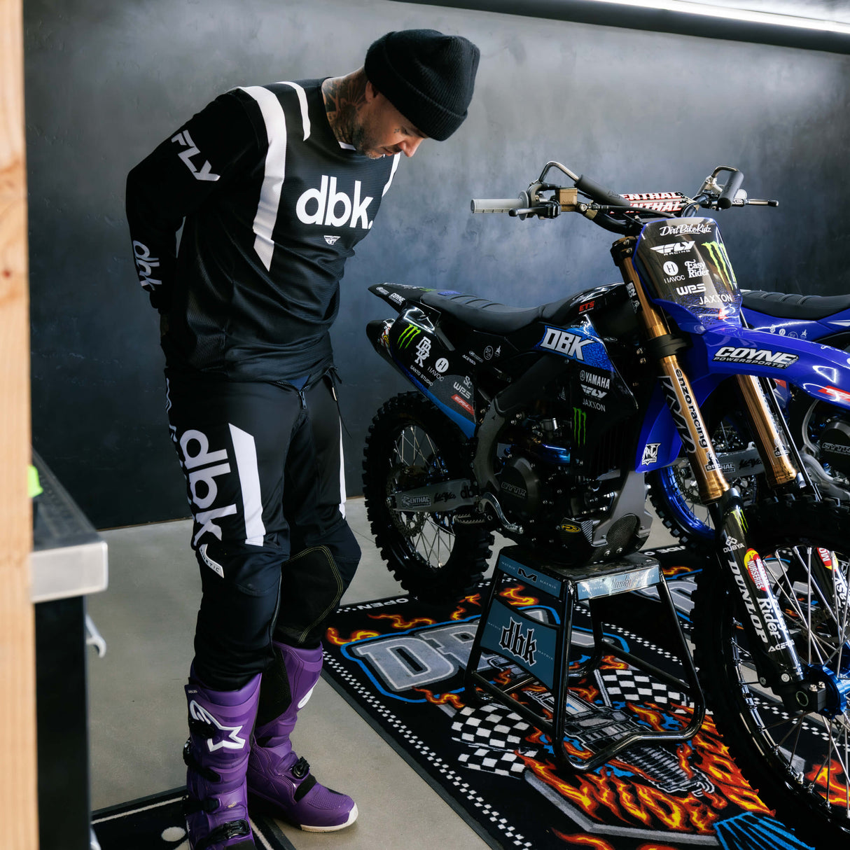 Black riding pants with white leg lettering and stitched knee armor panels