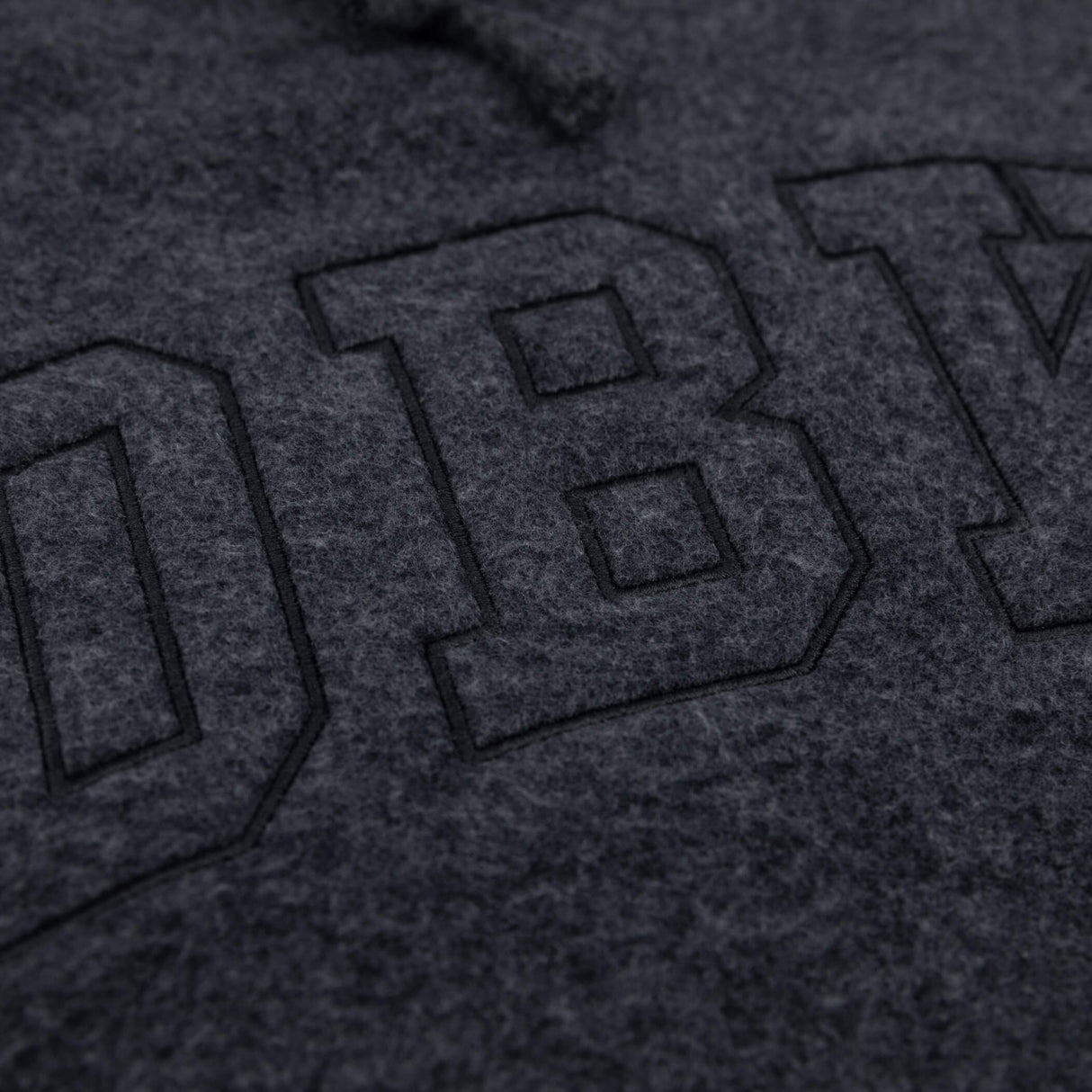 Women’s dark charcoal pullover hoodie extreme close-up of front logo graphic