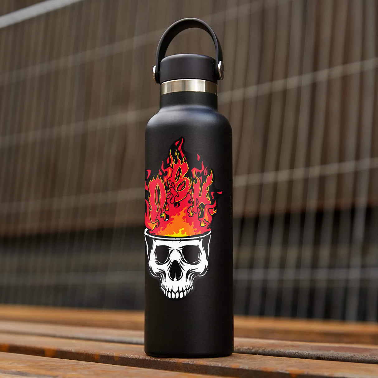 Flame skull sticker on matte black water bottle with metal carrying lid