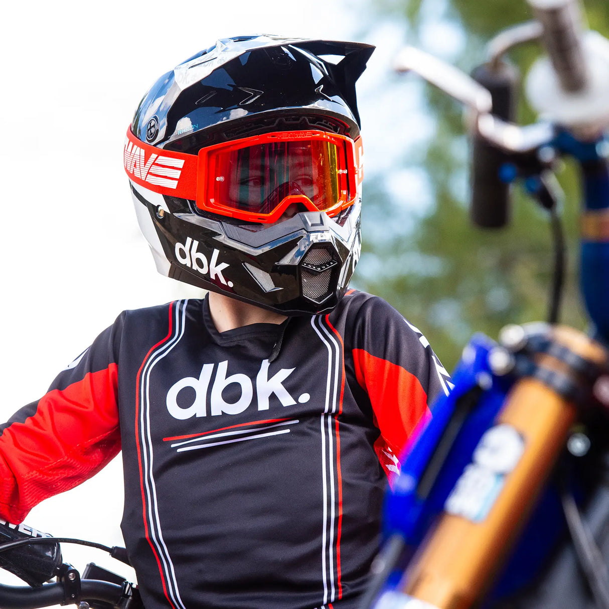 Youth riding jersey with black front panel, red sleeves, and striped accents, long sleeves