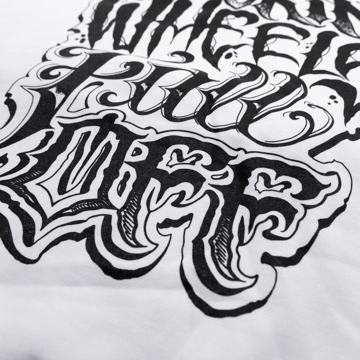 White hoodie close-up of white-and-black distressed word graphic on chest