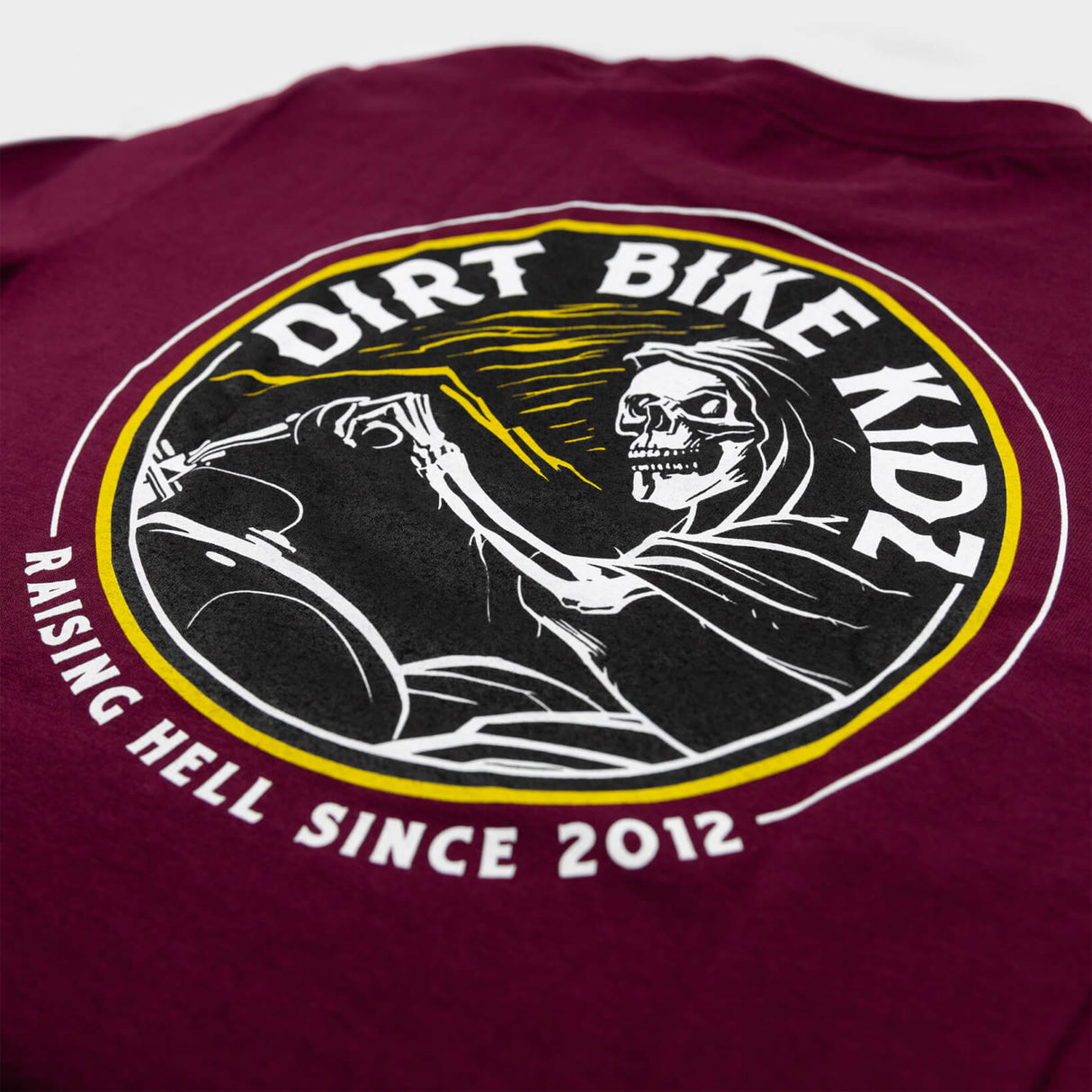 Reaper tee burgundy back close-up with Dirt Bike Kingdom riding skull graphic