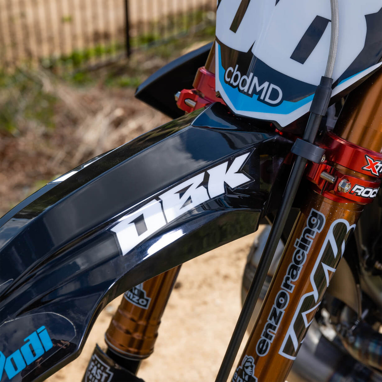 White racing wordmark decal on black front fender of a dirt bike