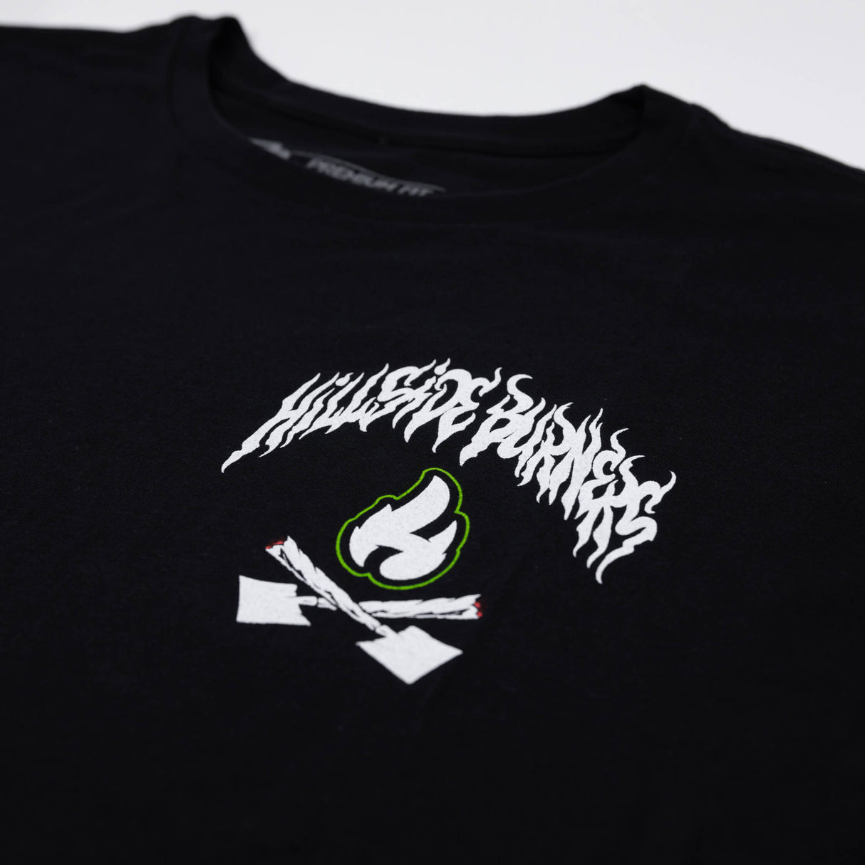 Black long T-shirt close-up of front graphic with white and green flame lettering
