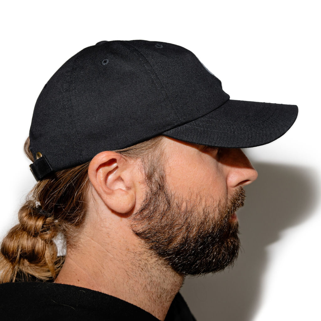 Black dad hat side profile with curved brim and stitching details