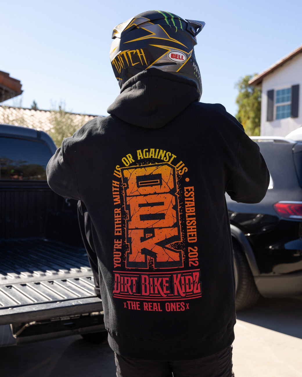 Black Tombstone hoodie back graphic print, orange-yellow logo and text, hood up