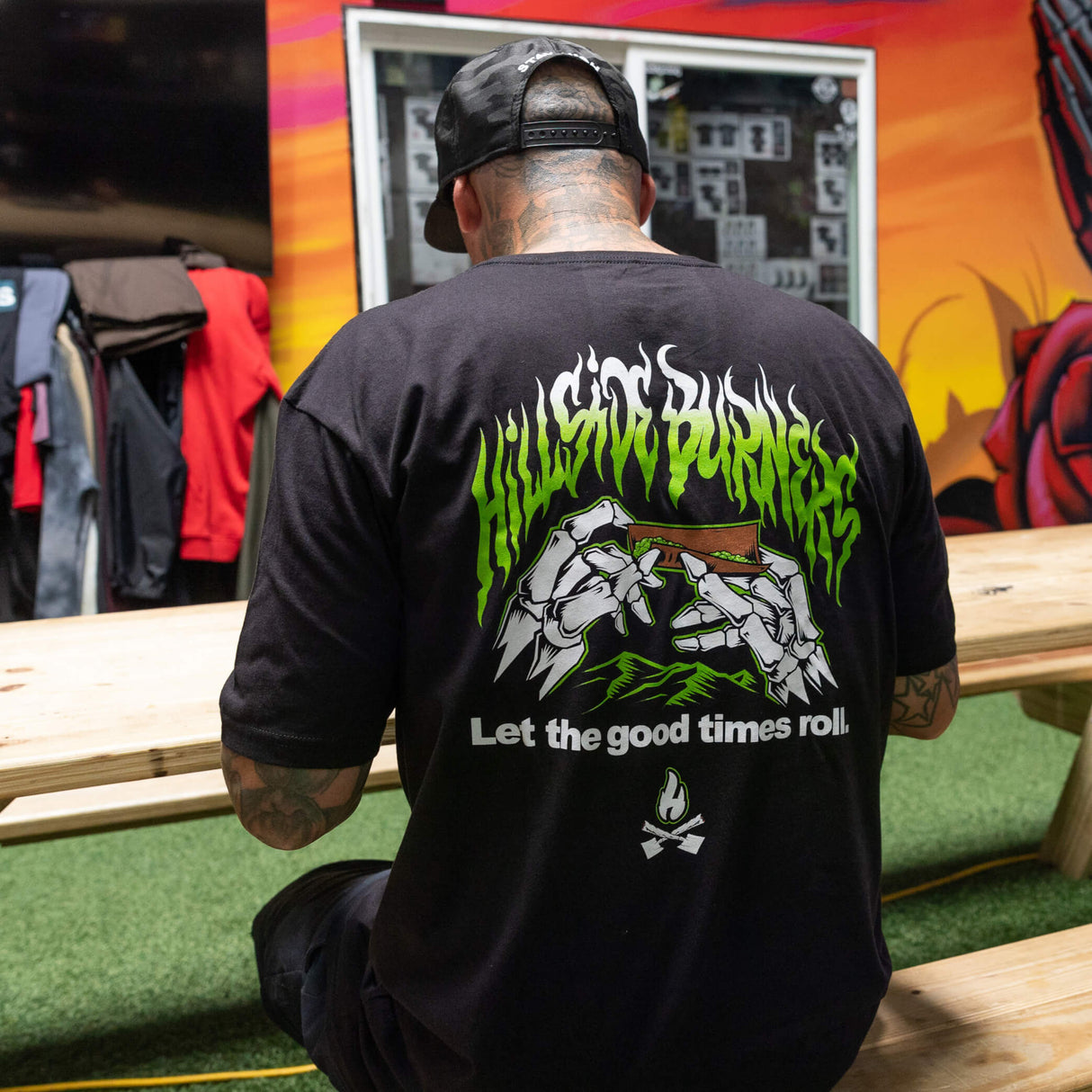 Black T-shirt back with green flame band, illustrated fists, and 'Let the good times roll'