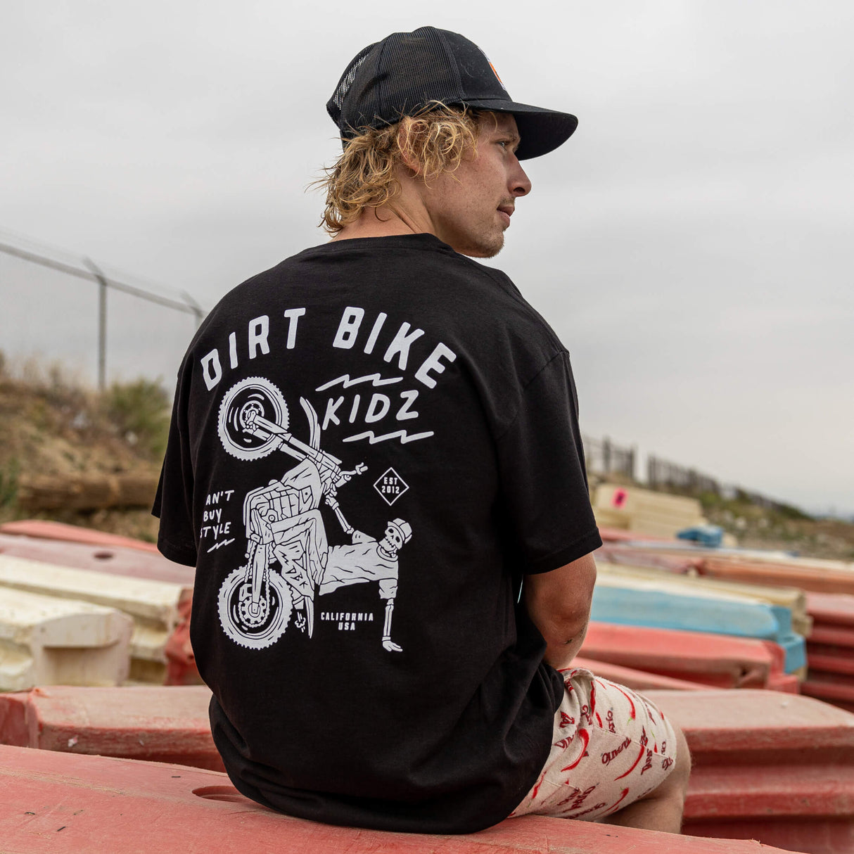 Black kids T-shirt worn by model, showing large back dirt bike rider graphic