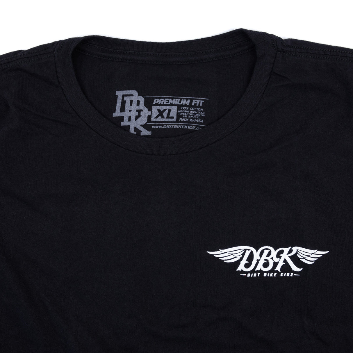 Black tall tee close-up of neckline and small winged DBK logo on chest