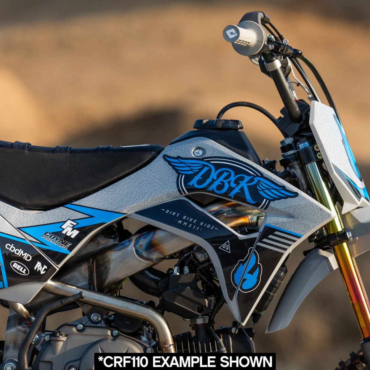 Close-up of blue/gray Hillside Burners tank panel with flame logo on a dirt bike