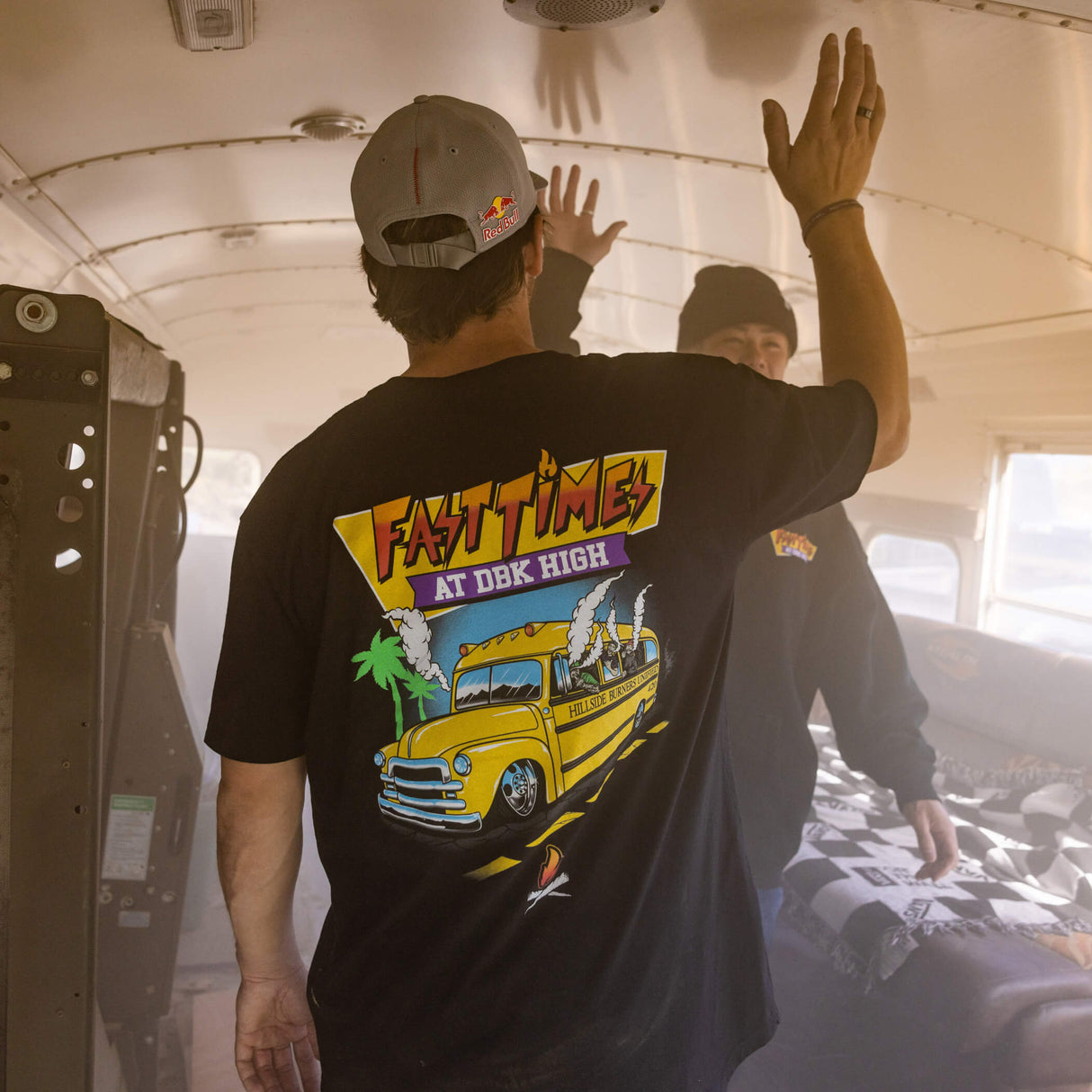 Black Fast Times graphic T-shirt shown from the back with “AT DBK HIGH” and bus artwork