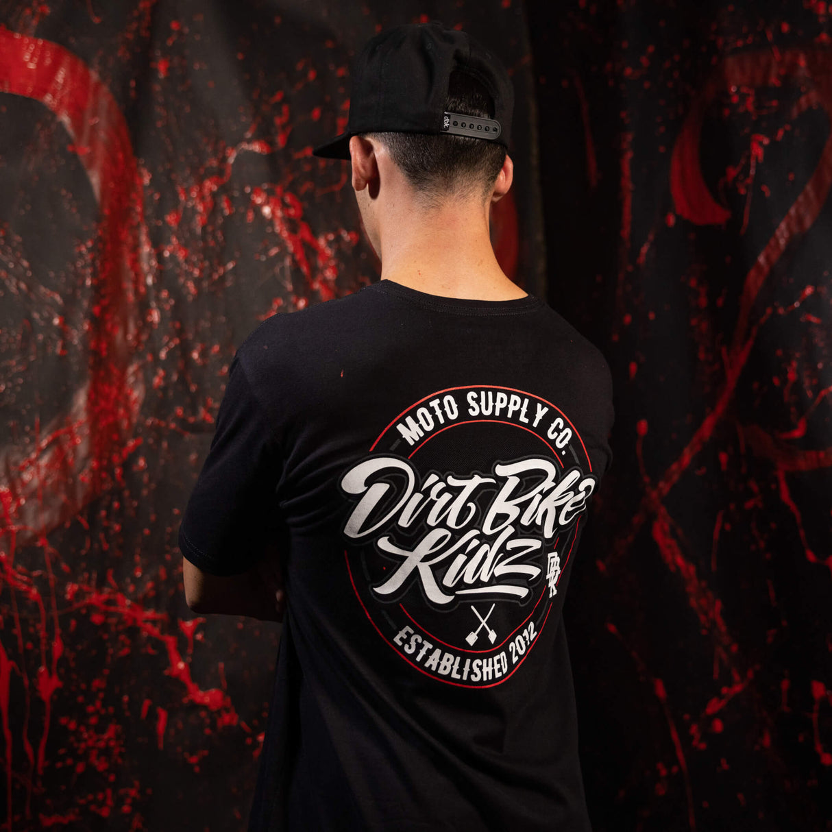 Black tall tee worn by model with large back graphic logo print
