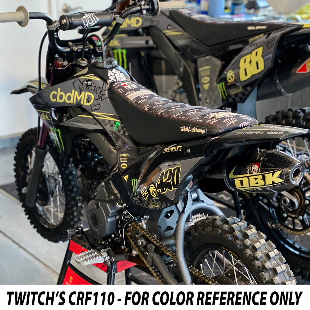 Close-up of KLX 110 graphics on black seat and side shrouds with yellow details