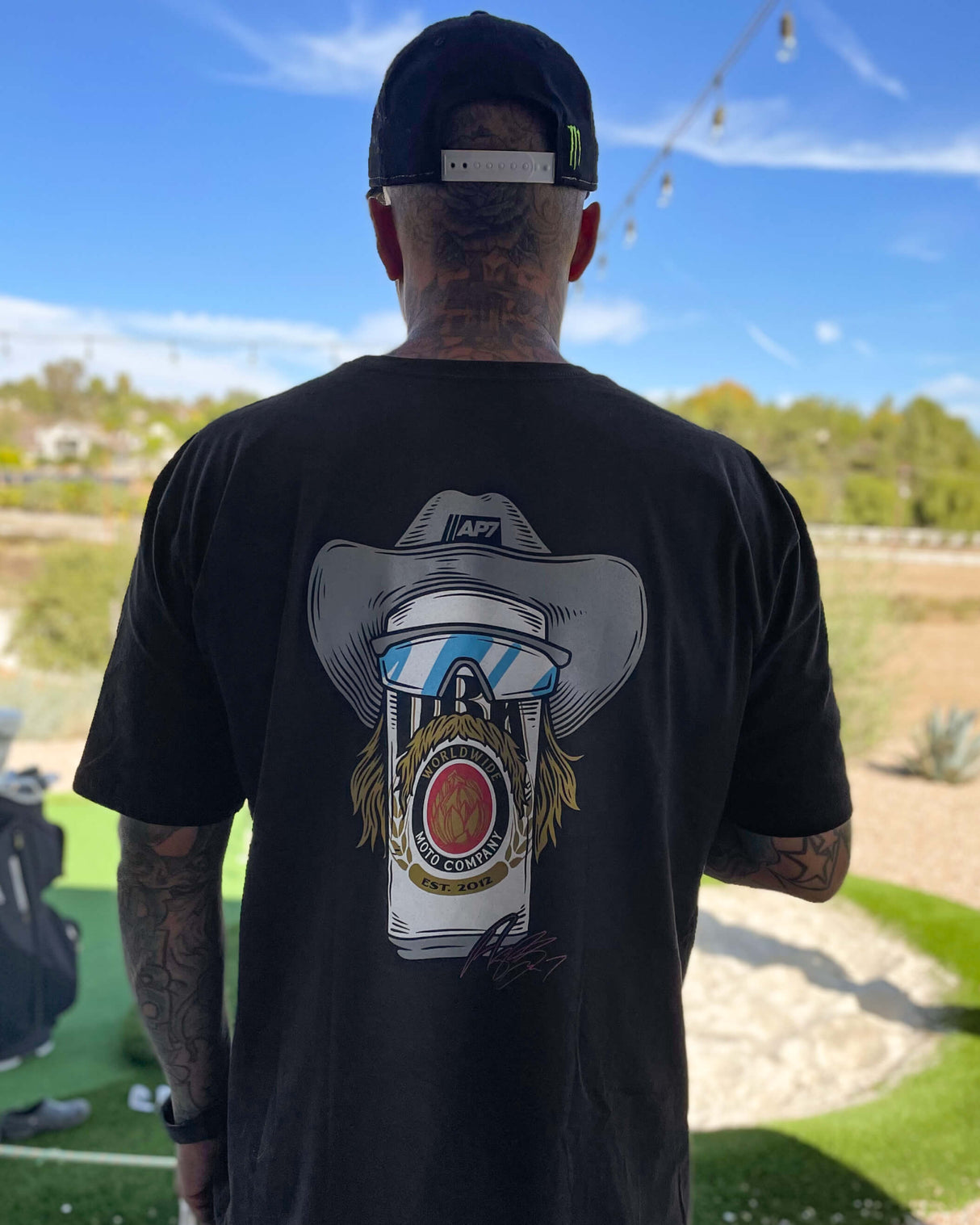 Black crewneck graphic tee worn by model, back cowboy hat “WORLDWIDE” graphic