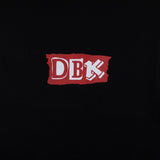 Black Shifting Gears tee close-up of red DBK logo