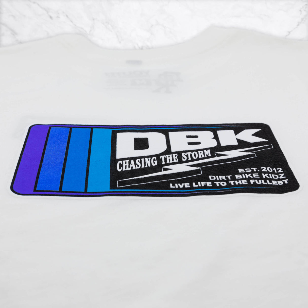 Youth premium tee graphic close-up, white with DBK logo patch