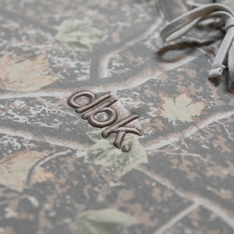 Embroidered “dbk” logo on camouflage hoodie chest