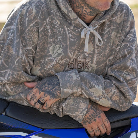 Backwoods camouflage hoodie front pocket and “dbk” logo