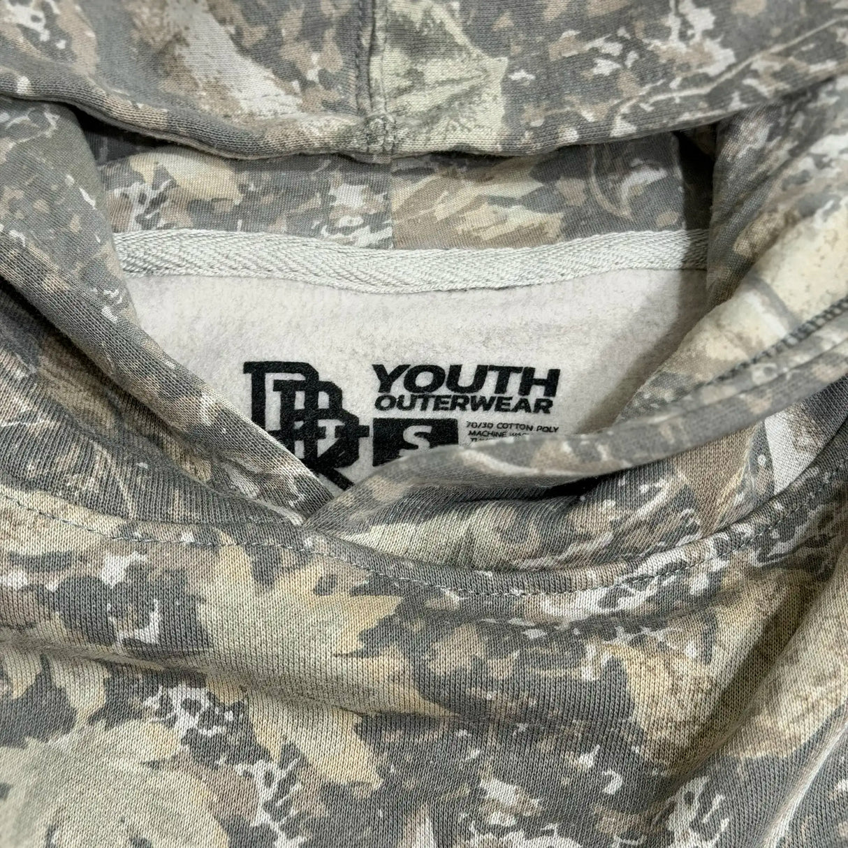 Youth camouflage hoodie neck label showing “YOUTH OUTERWEAR” branding.