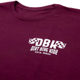 Maroon graphic T-shirt close-up of chest DBK logo and “ESTD. MMXII”